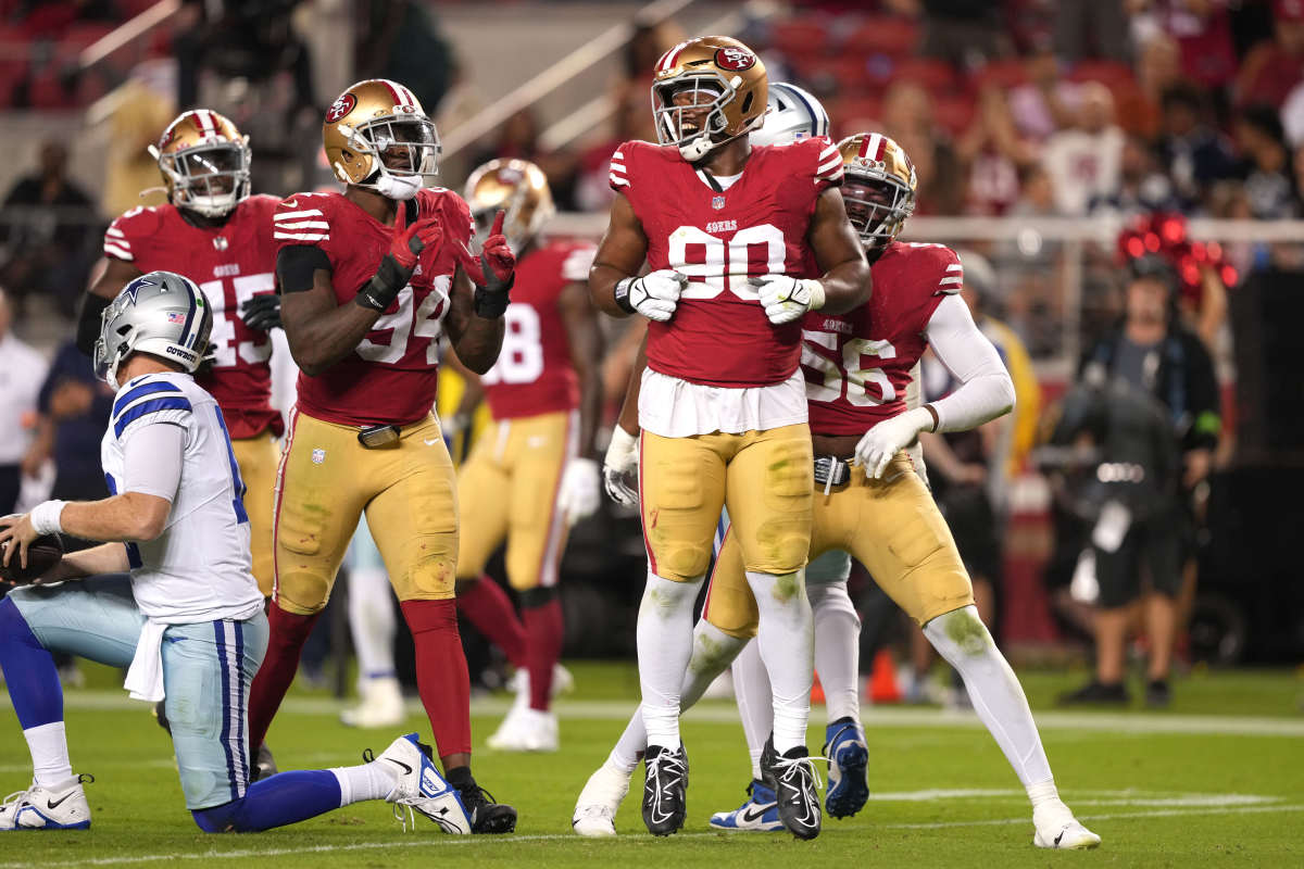 Kevin Givens jumps up and down celebrating a sack while other linemen clap around him
